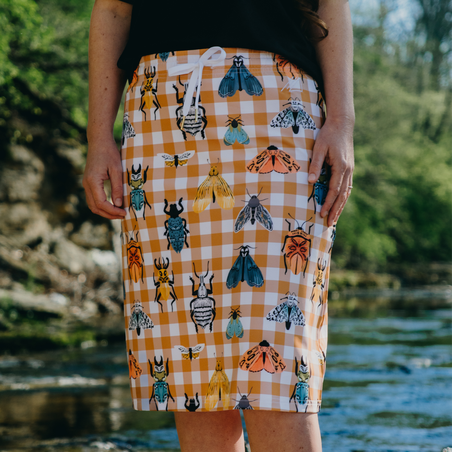 Person wearing a skirt with insect pattern in a natural setting