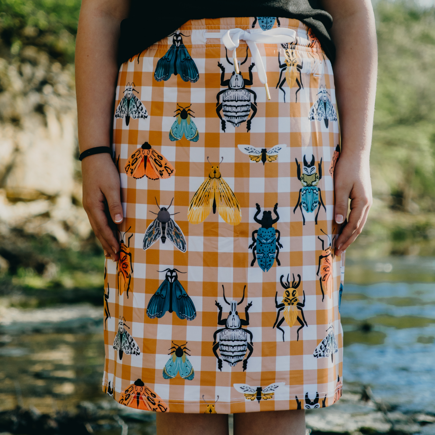 Kid wearing a skirt with insect pattern outdoors