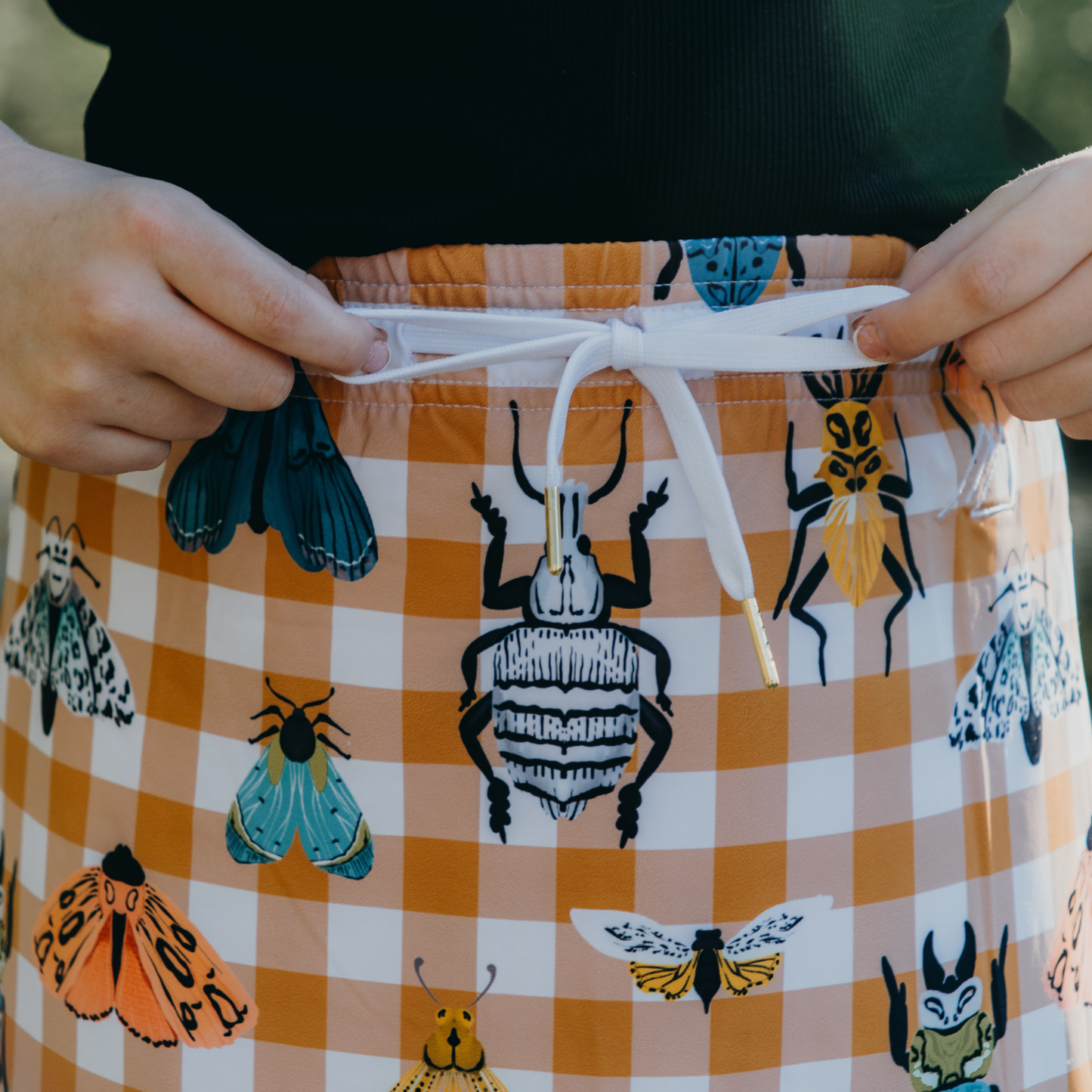 
                  
                    kid wearing skirt with insect pattern and gingham check
                  
                