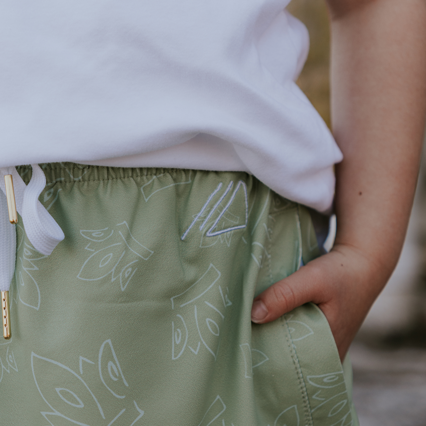 
                  
                    Person wearing a white top and green skirt with white patterns, standing outdoors.
                  
                