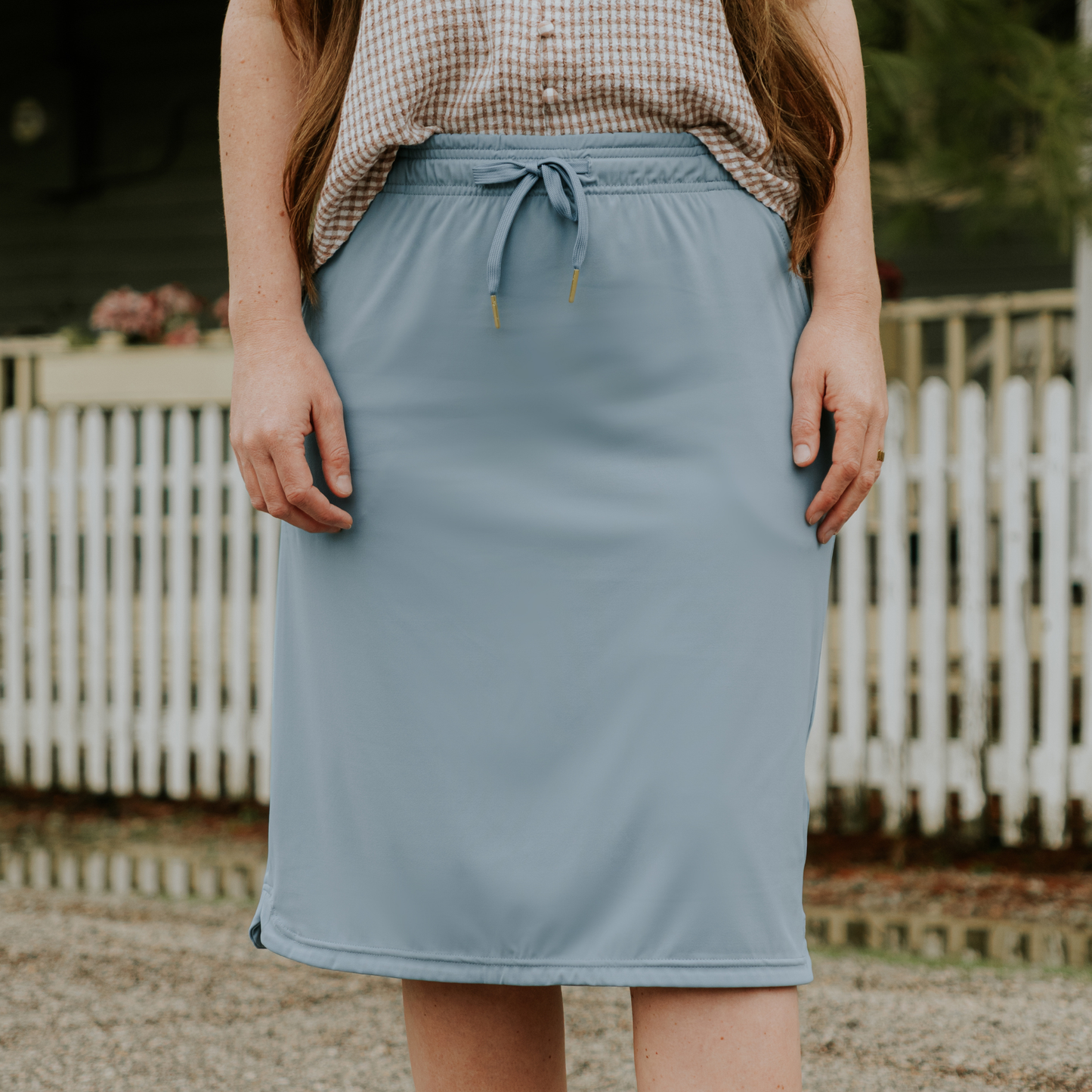 Person wearing a light blue skirt with a blurred background