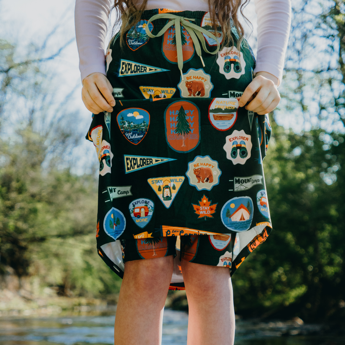 
                  
                    Person wearing a skirt with shorts with nature-themed patches outdoors
                  
                