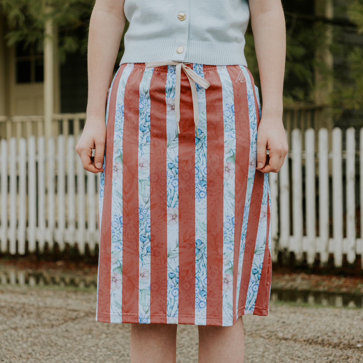 Person wearing a patterned skirt with a blurred background