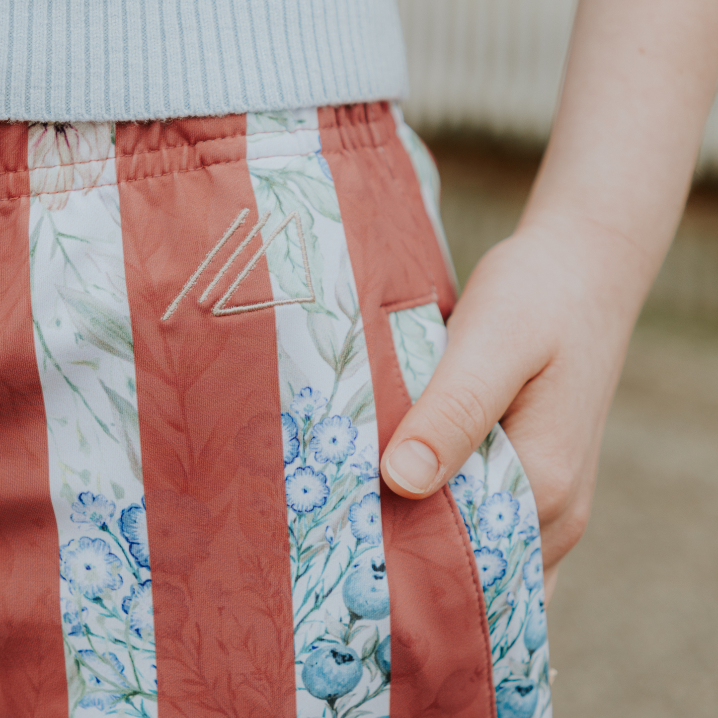 
                  
                    Close-up of a person wearing floral skirt with a patterned waistband.
                  
                