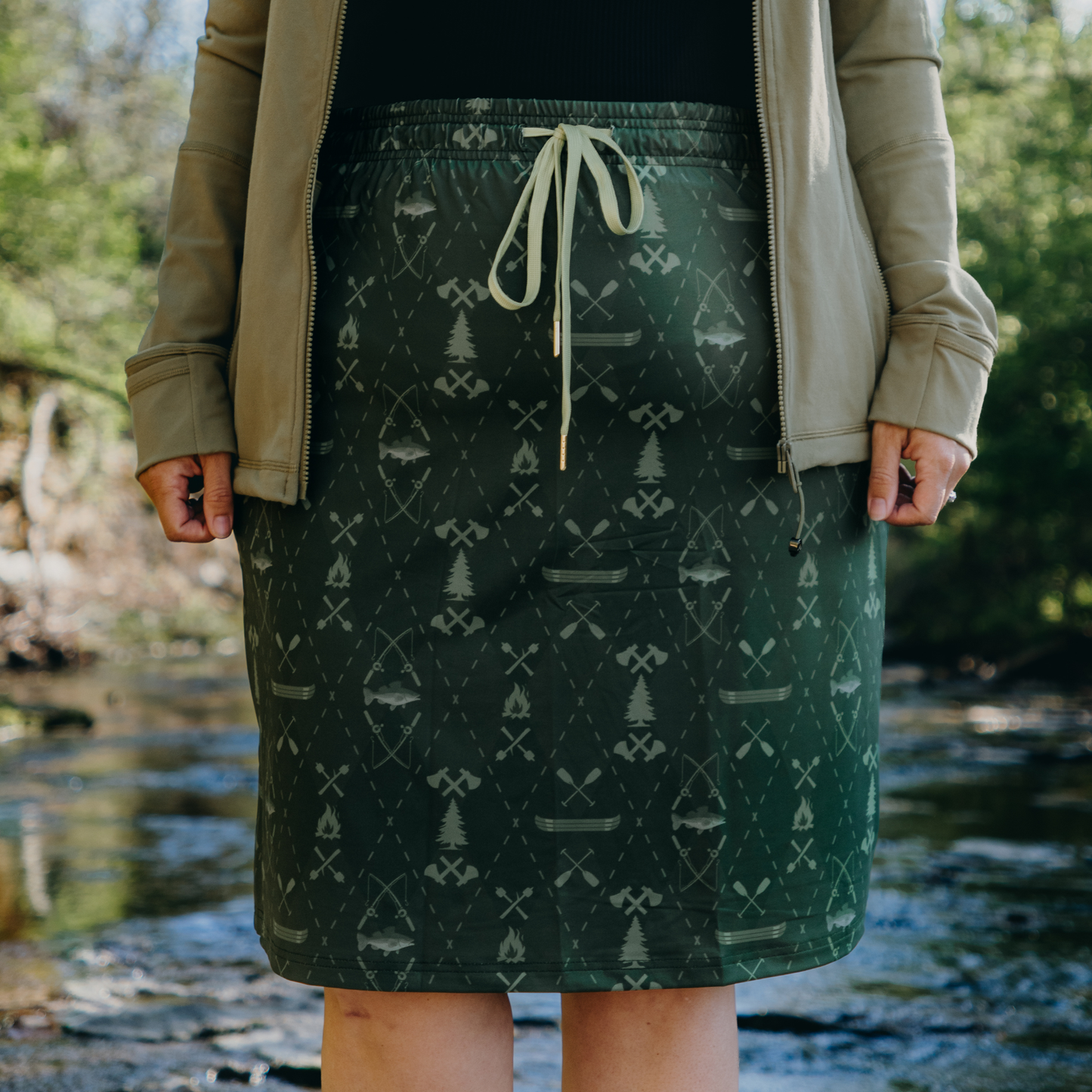 Person wearing a green patterned skirt with a natural background